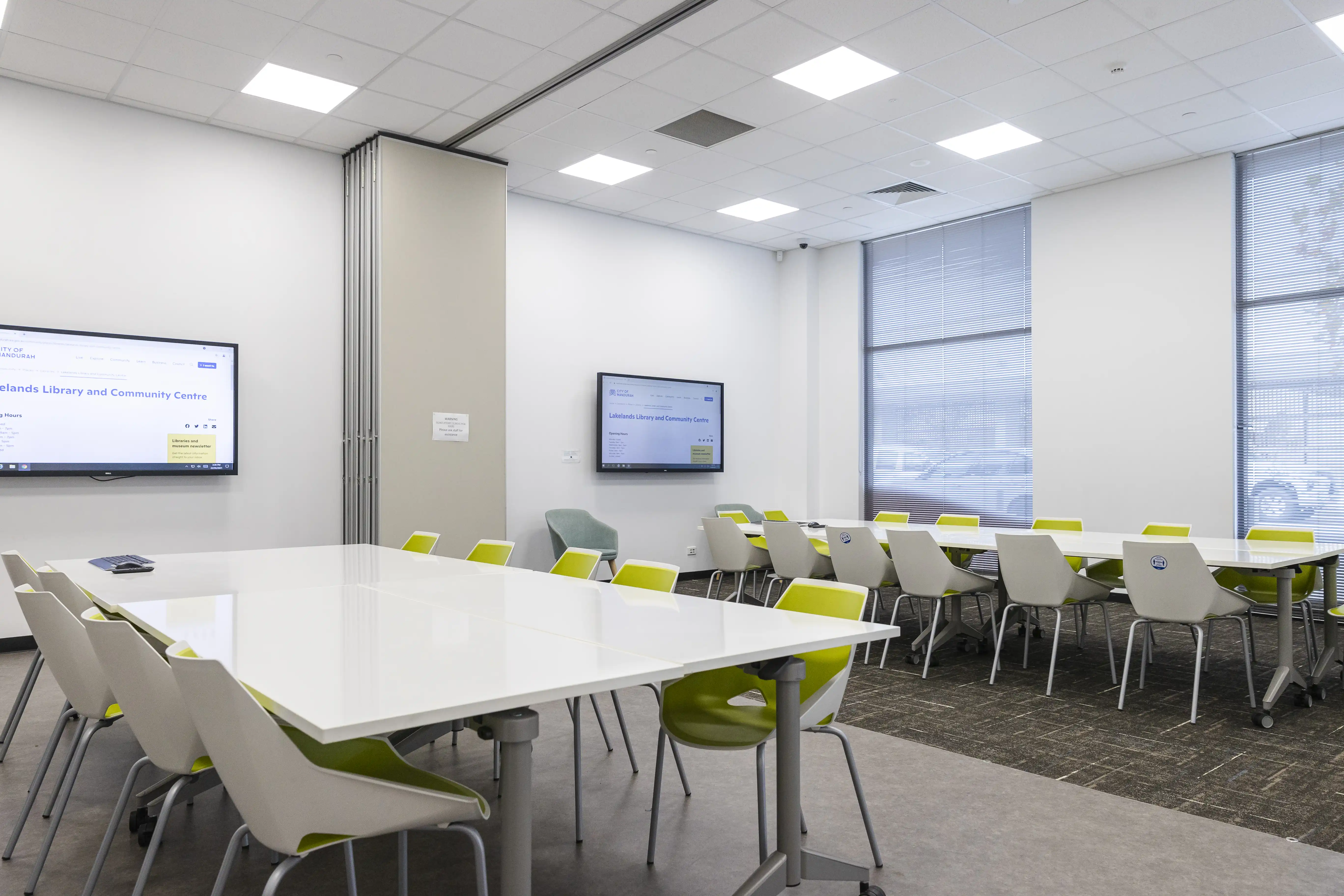 Lakelands Library Hire Space with desks, tables and tv screens.